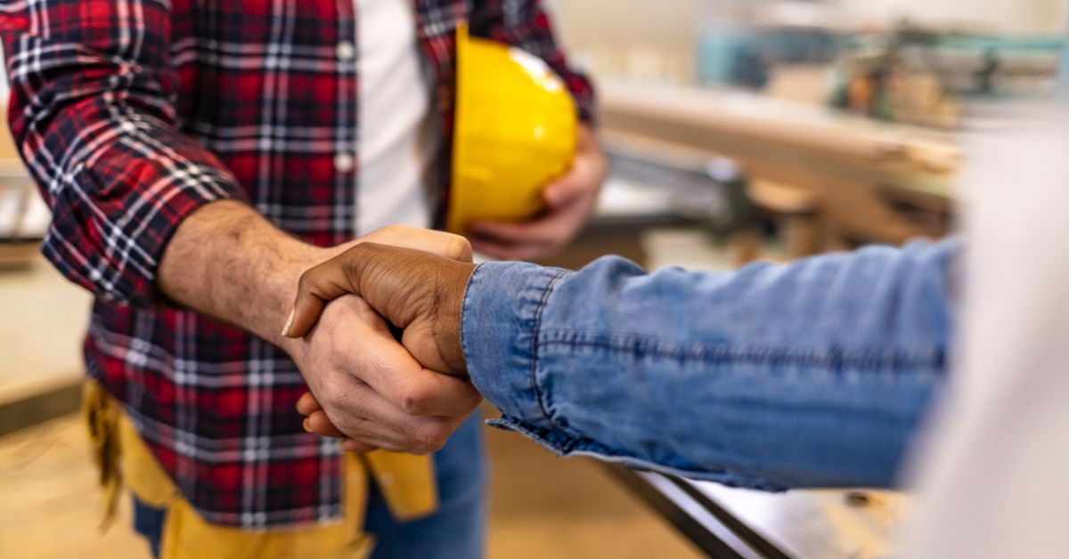 homeowner shaking hands with roofing professional