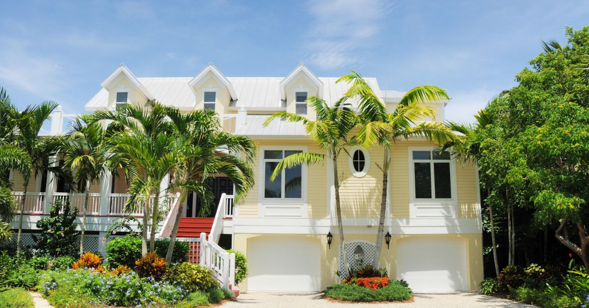 nice white mansion with spanish clay tile roof with palm trees and hot sun