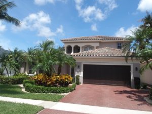 front of tan mansion with spanish style clay tile roof